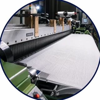 Dornier rapier loom weaving white filtration fabric off the reed