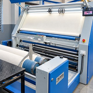 Rolling cum inspection machine at DFR with fabric over the lit screen
